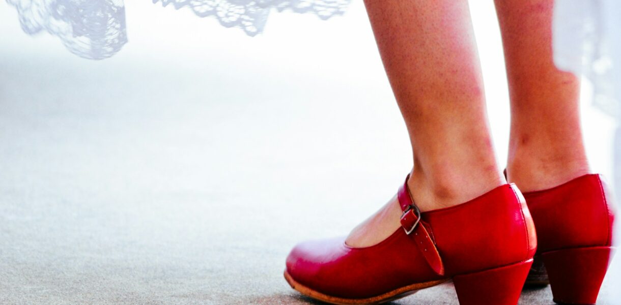 a close up of a person wearing red shoes
